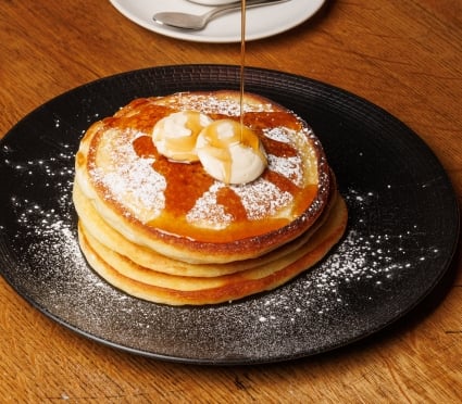 syrup pouring onto pancakes