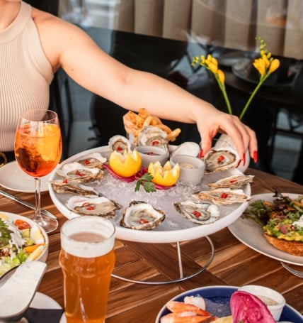 plate of dressed oysters and cocktails on large tray