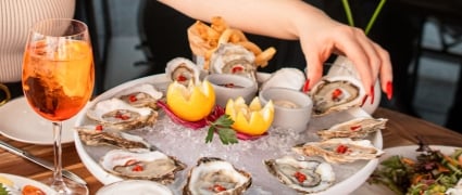 Friends having a good time at Gallery Bar in Tribeca, with table full of spread with seafood and drinks