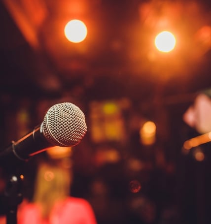 Microphone on stage against a background of auditorium.