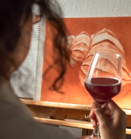 Woman drinking a glass of wine while looking at art