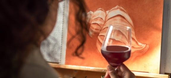 Woman drinking a glass of wine while looking at art