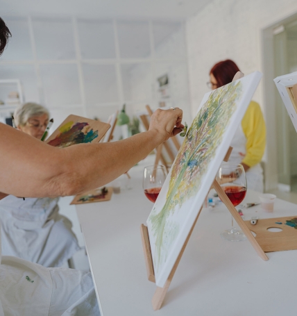 Mature woman painting in paint and sip class