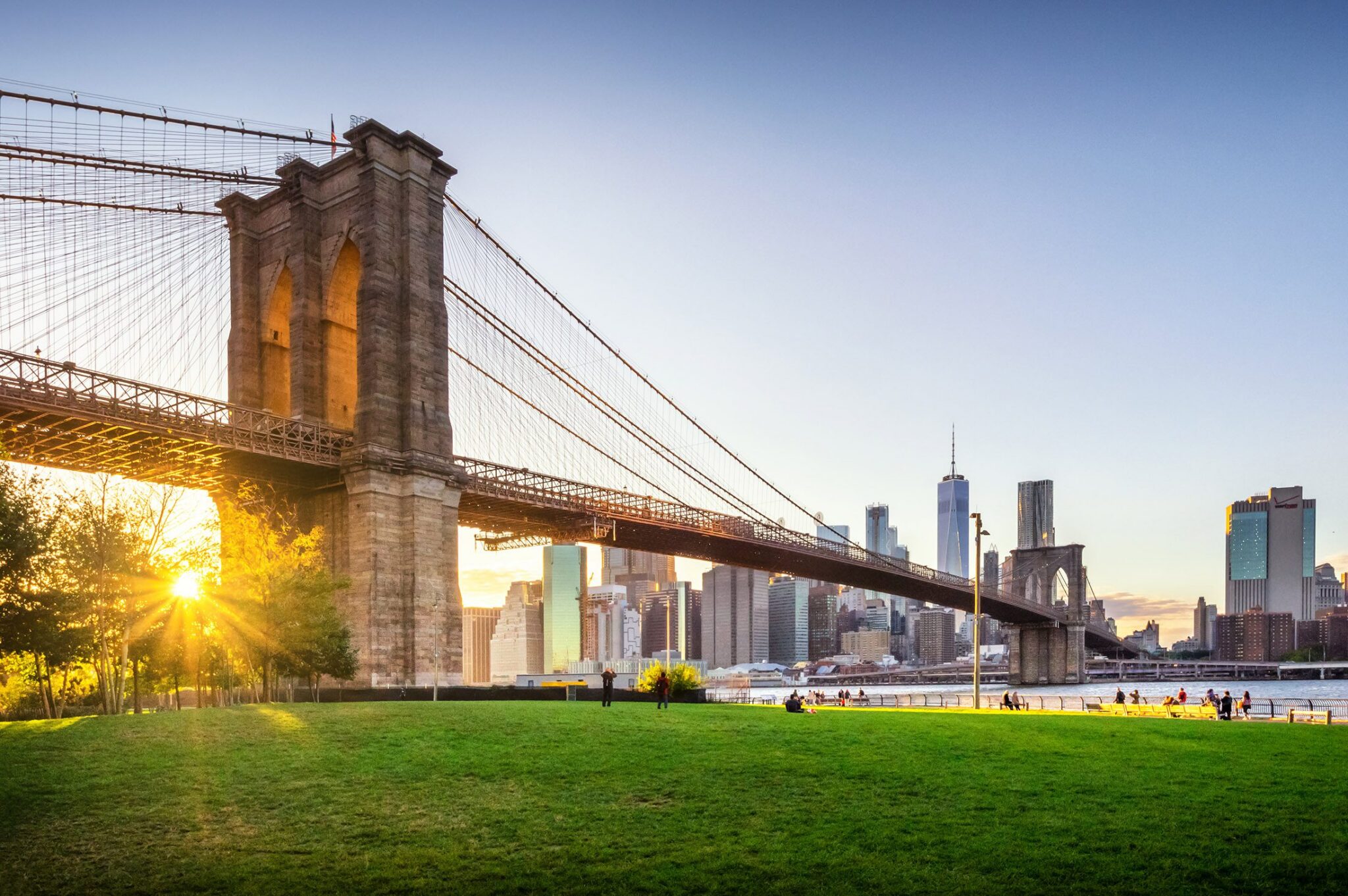 A wide shot of the Brooklyn Bridge with the New York City skyline in the background.